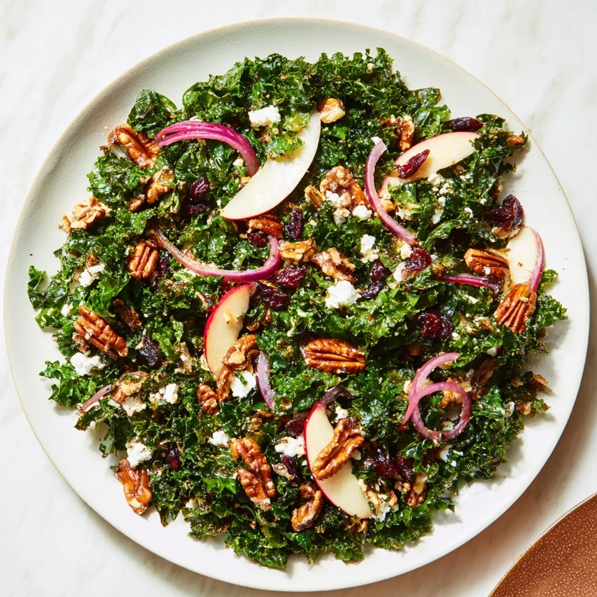A colorful Winter Kale Salad with pecans, cranberries, and tangy vinaigrette, ready to be enjoyed.