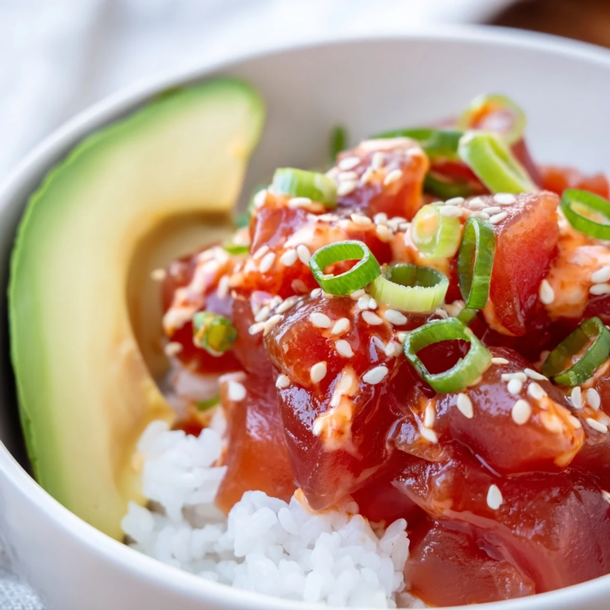This vibrant Spicy Tuna Roll Bowl features julienned cucumber, carrots, and a drizzle of sriracha mayo.
