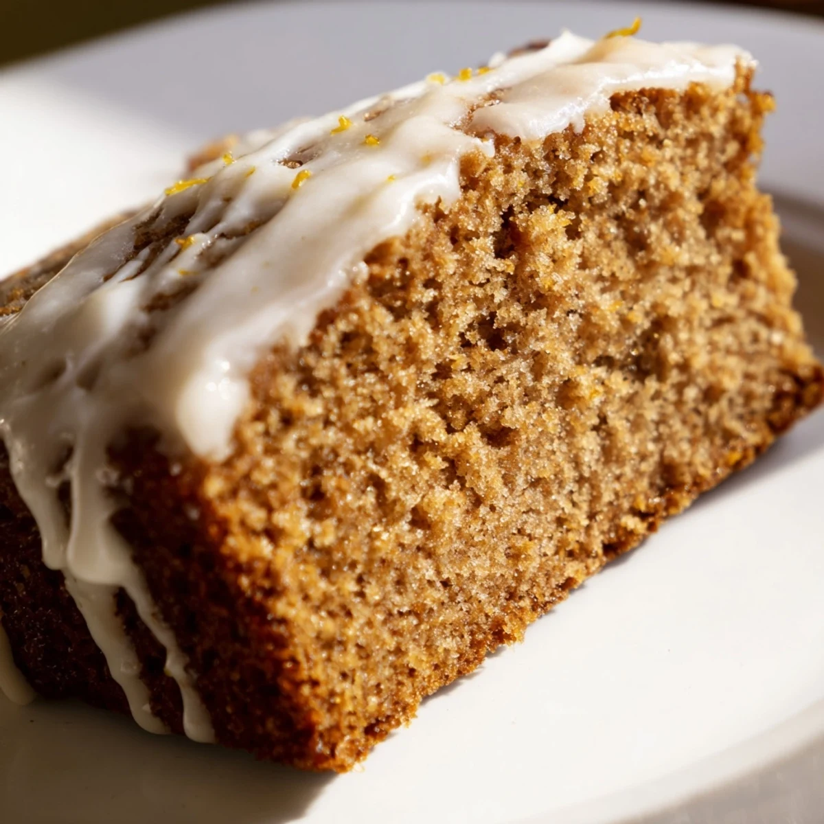 Warmly spiced Gingerbread Loaf with Lemon Cream Cheese Glaze, sliced to reveal a moist, tender crumb.