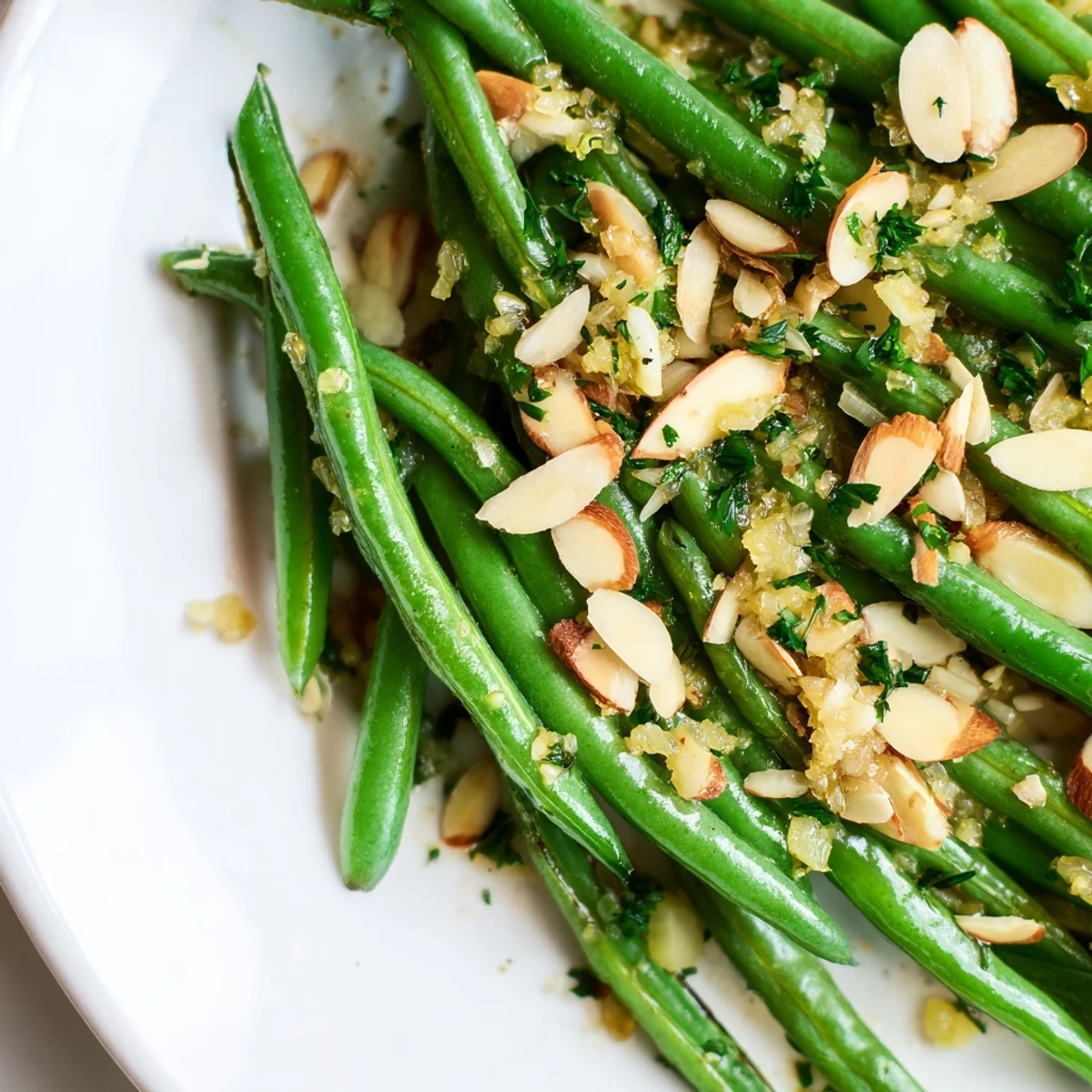 Vibrant green beans topped with toasted almonds on a white plate, ready to serve alongside grilled chicken.