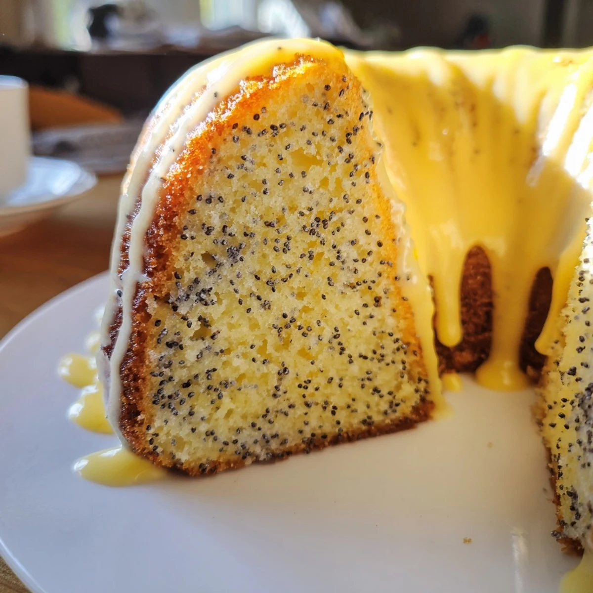 Lemon Poppy Seed Bundt Cake drizzled with bright glaze, sliced to reveal tender interior perfect for tea time.