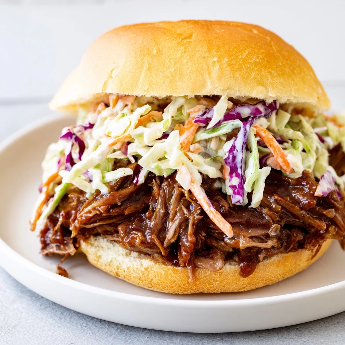 Golden-brown, tender pulled beef piled high on a toasted brioche bun, generously topped with creamy, tangy homemade coleslaw.