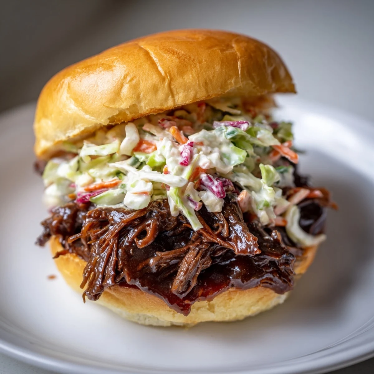 Close-up of a delicious MVP Pulled Beef Sandwich with coleslaw, perfect for a casual game day gathering.