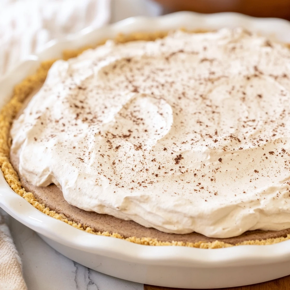 A slice of Keto Cold Brew Coffee Pie reveals its rich, no-bake texture and garnish of coffee beans, perfect for a keto dessert.