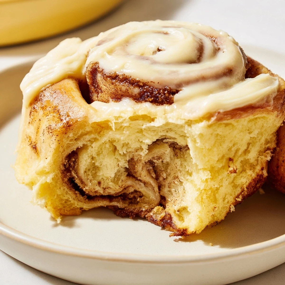 Warmly iced Keto Cinnamon Buns resting on a rustic wooden board, showcasing a soft, fluffy swirl.