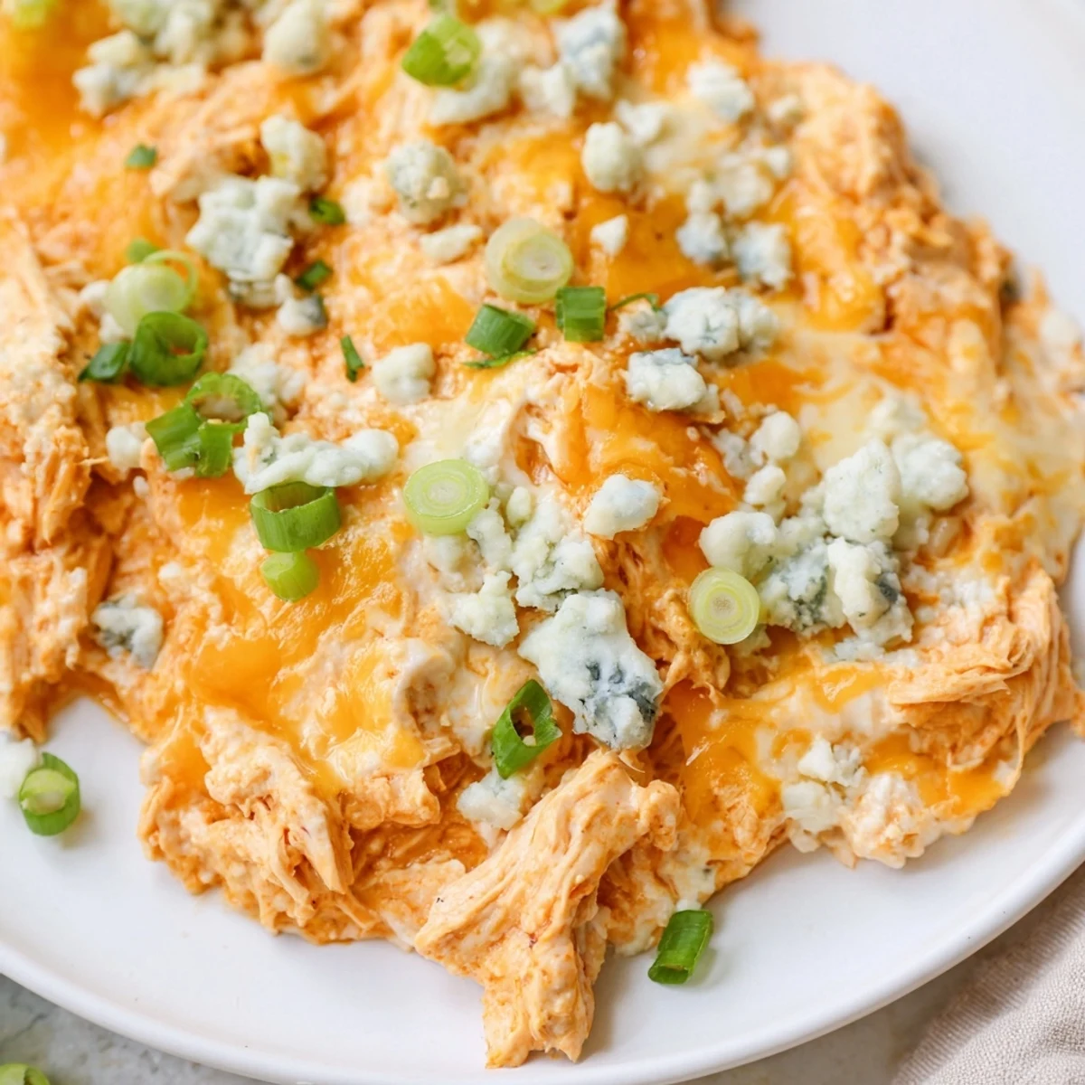 Keto Buffalo Chicken Dip baked golden with bubbly mozzarella and sharp cheddar on top.