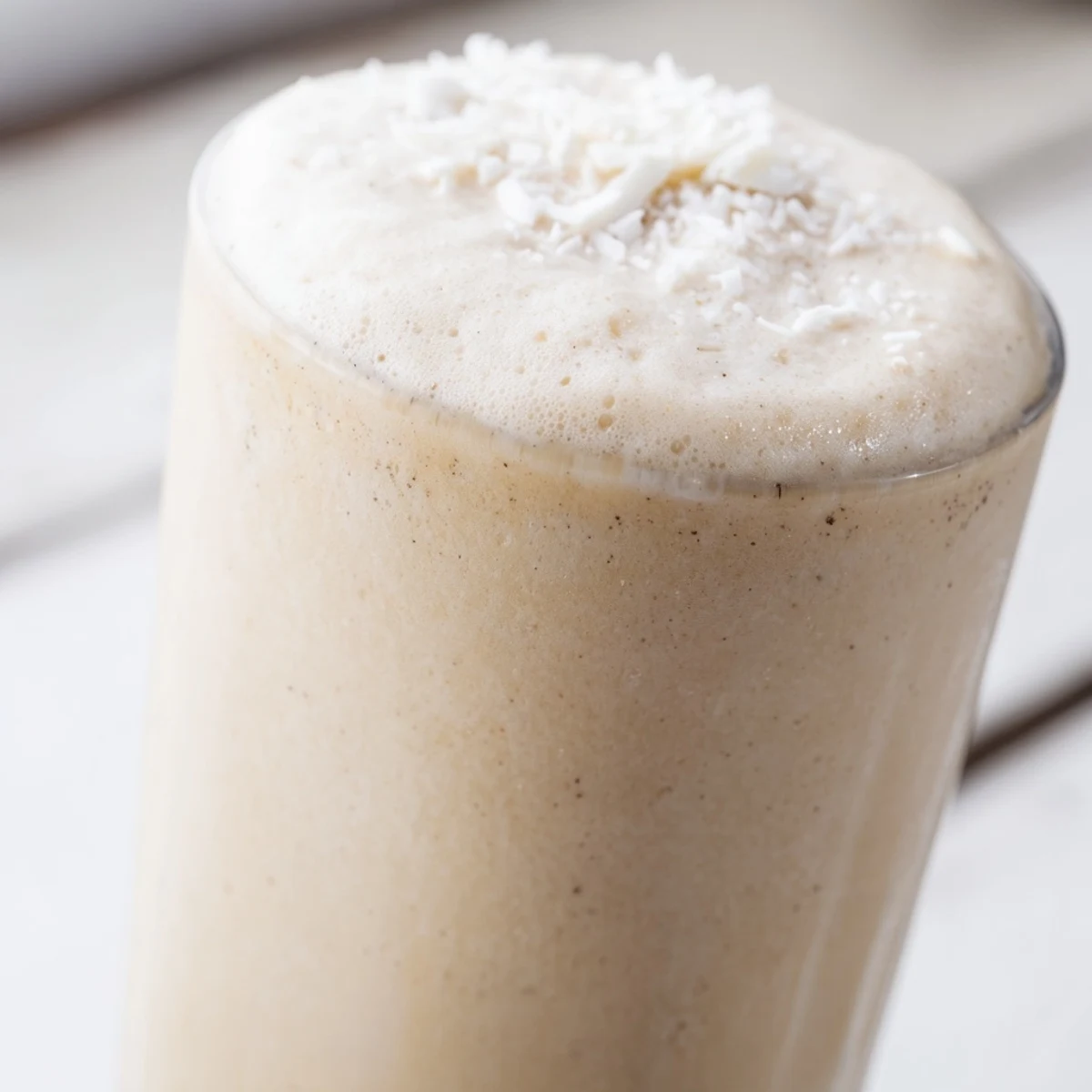 Homemade Vanilla Bean Frappuccino showing frosty blended texture with ice and vanilla bean seeds.