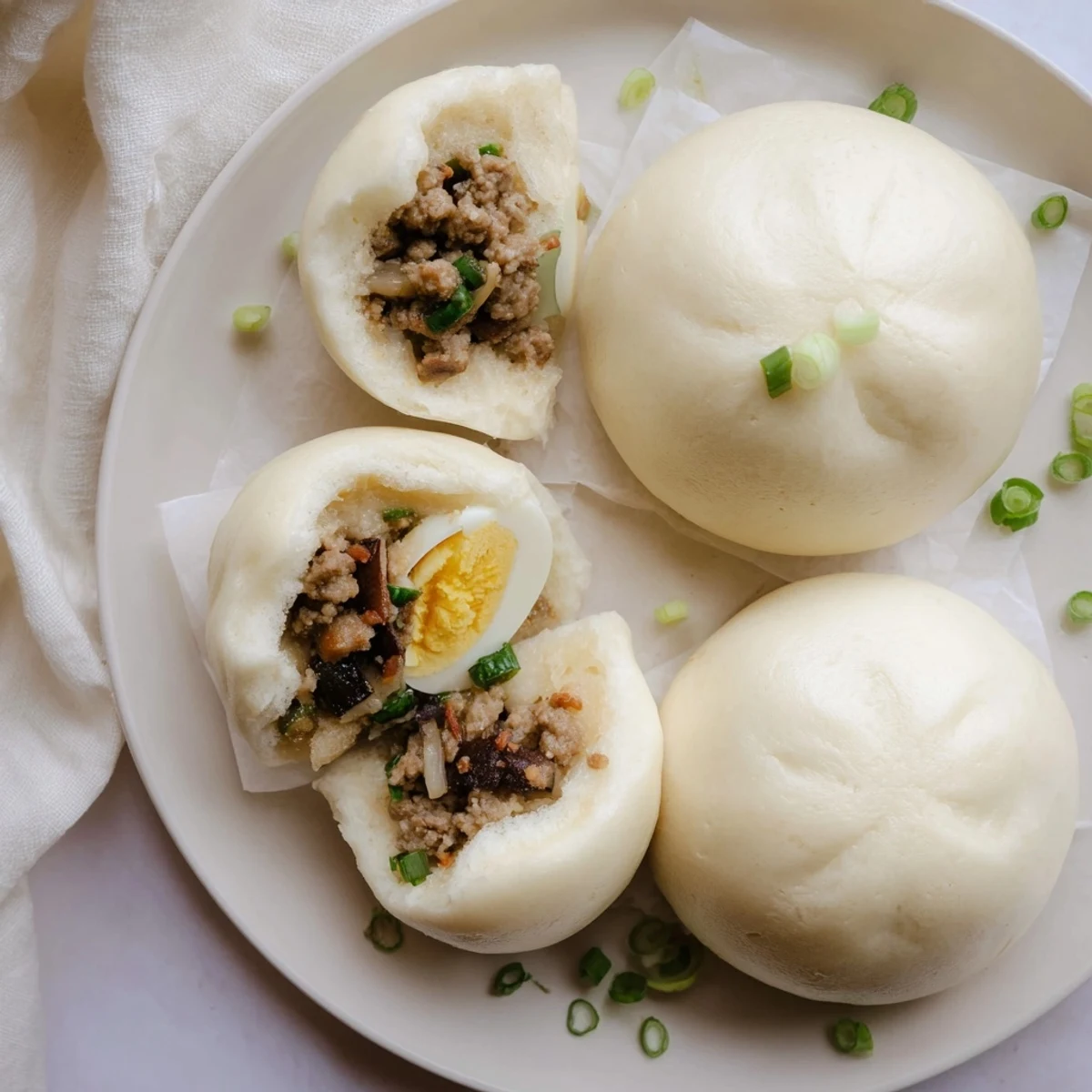 Golden steamed Banh Bao buns served on a bamboo tray, perfect for a light Vietnamese snack.