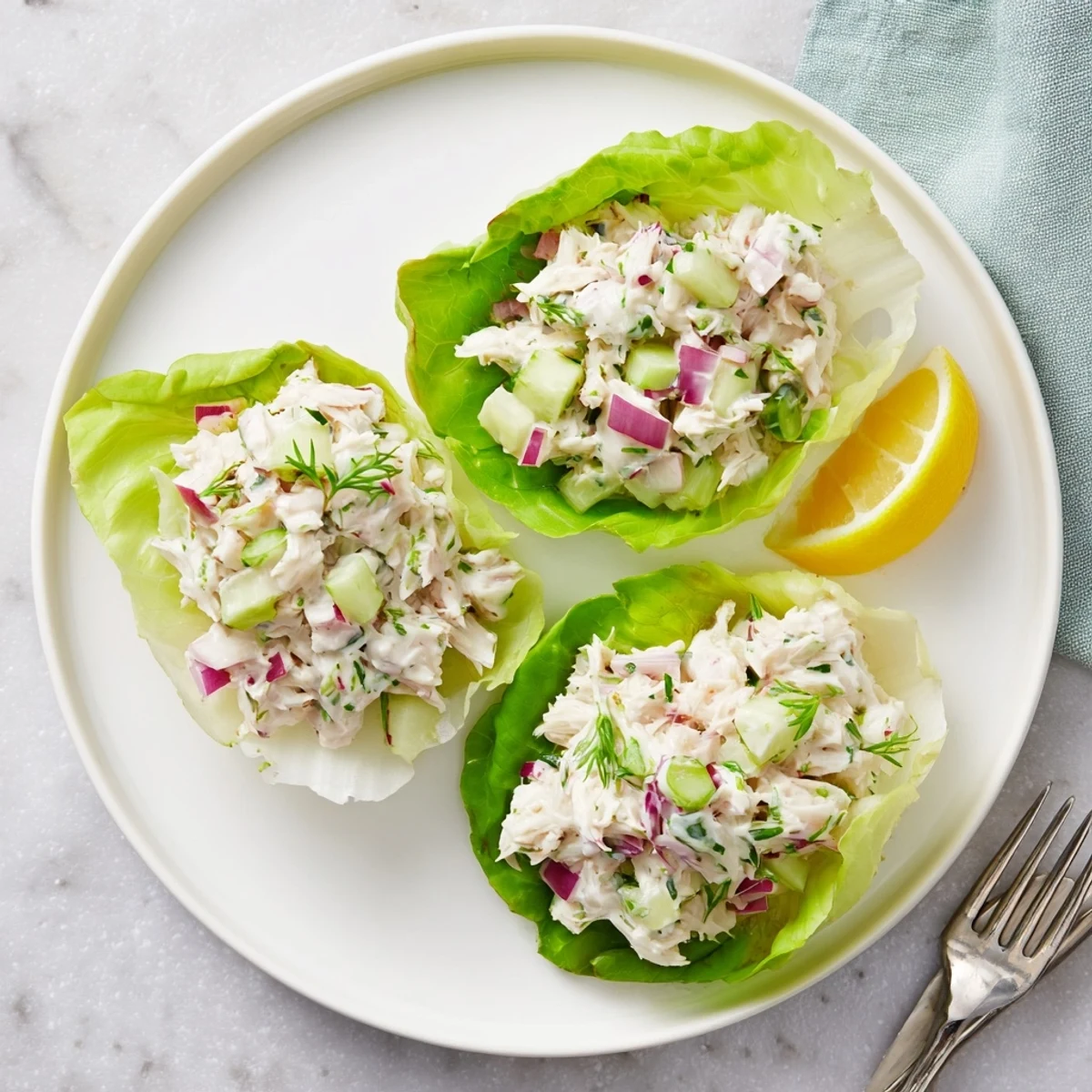 A close view of the refreshing Crab Salad garnished with fresh chives and served with lemon wedges for brightness.