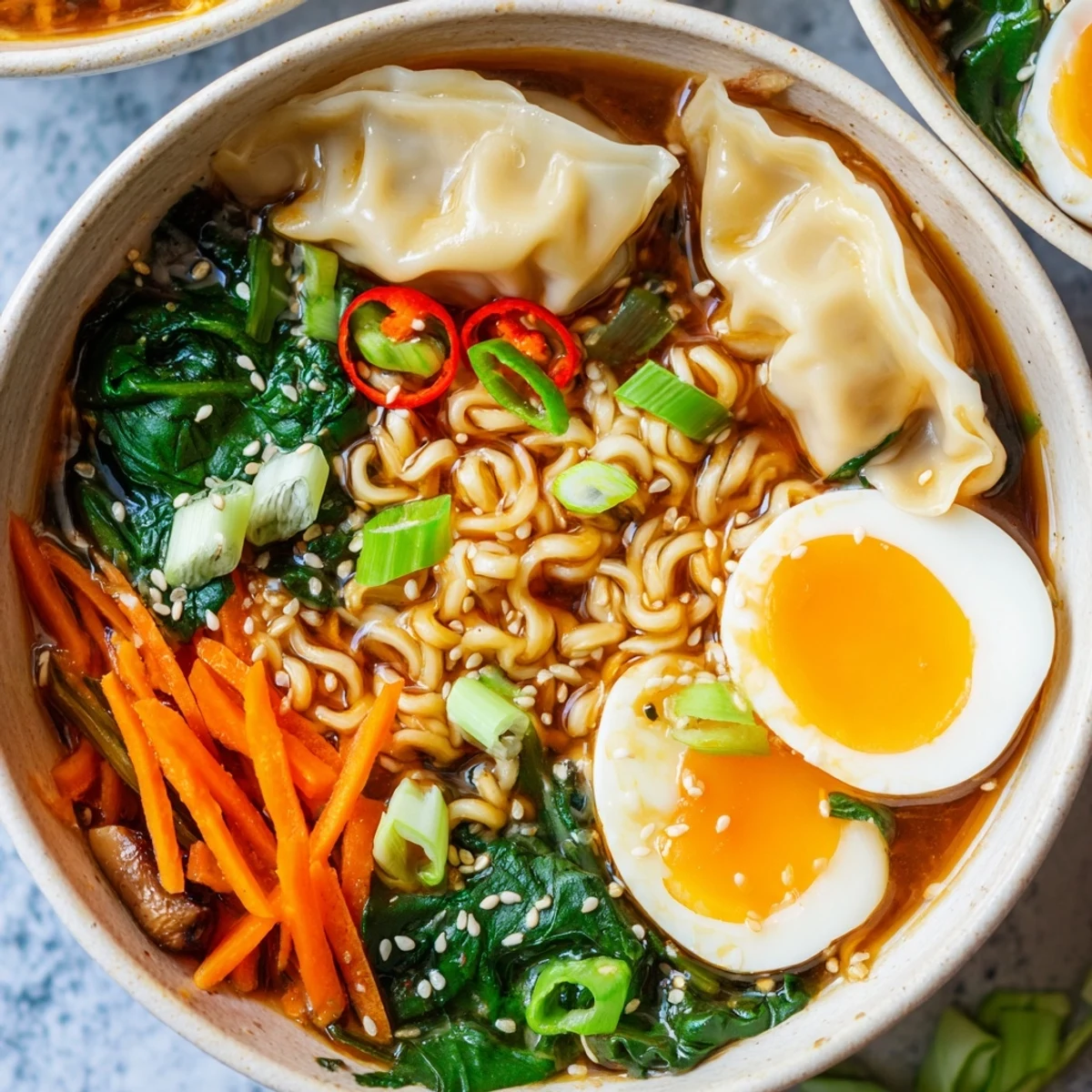 Steaming dumpling ramen bowl featuring tender dumplings in savory broth with fresh vegetables