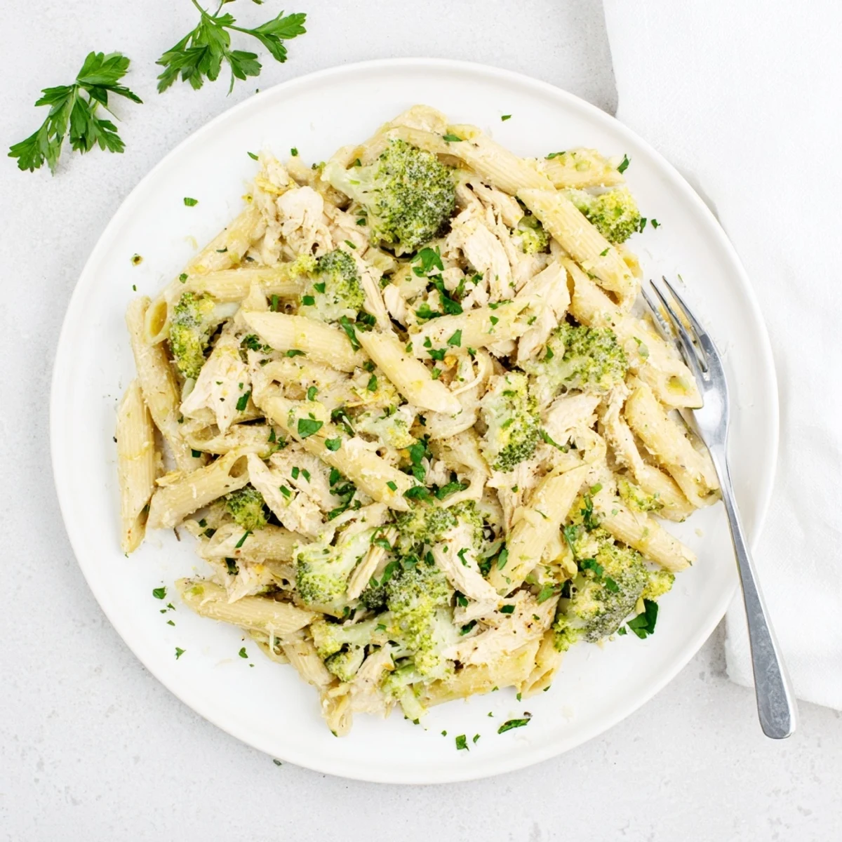 Creamy rotisserie chicken broccoli pasta tossed in garlic Parmesan sauce and garnished with fresh parsley