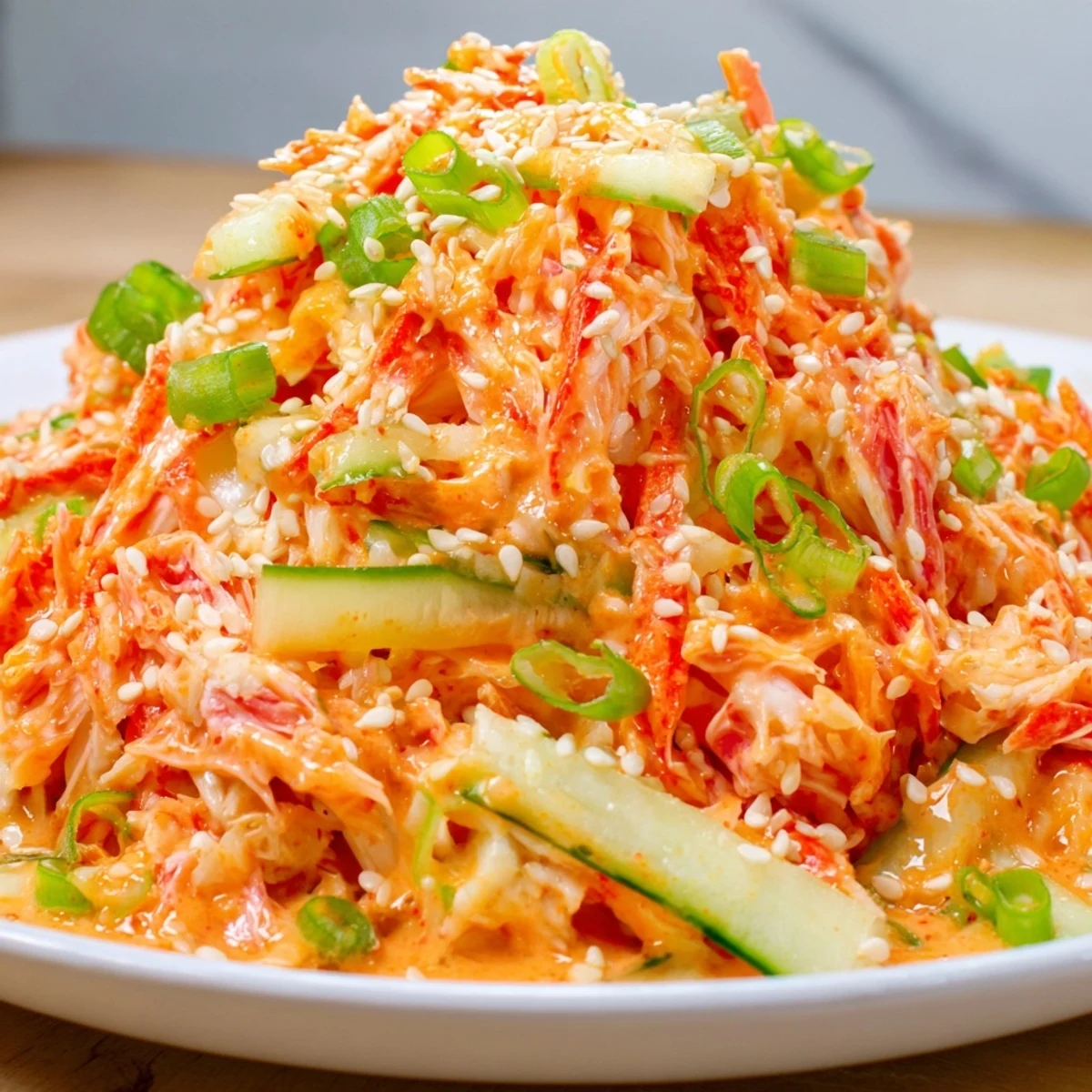 Close-up of Japanese spicy kani salad tossed in spicy mayo dressing with green onion sprinkles
