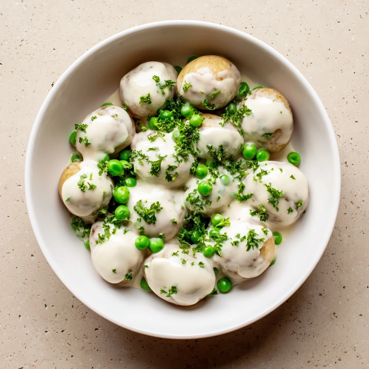 Golden baby potatoes and sweet green peas swimming in a velvety homemade white sauce