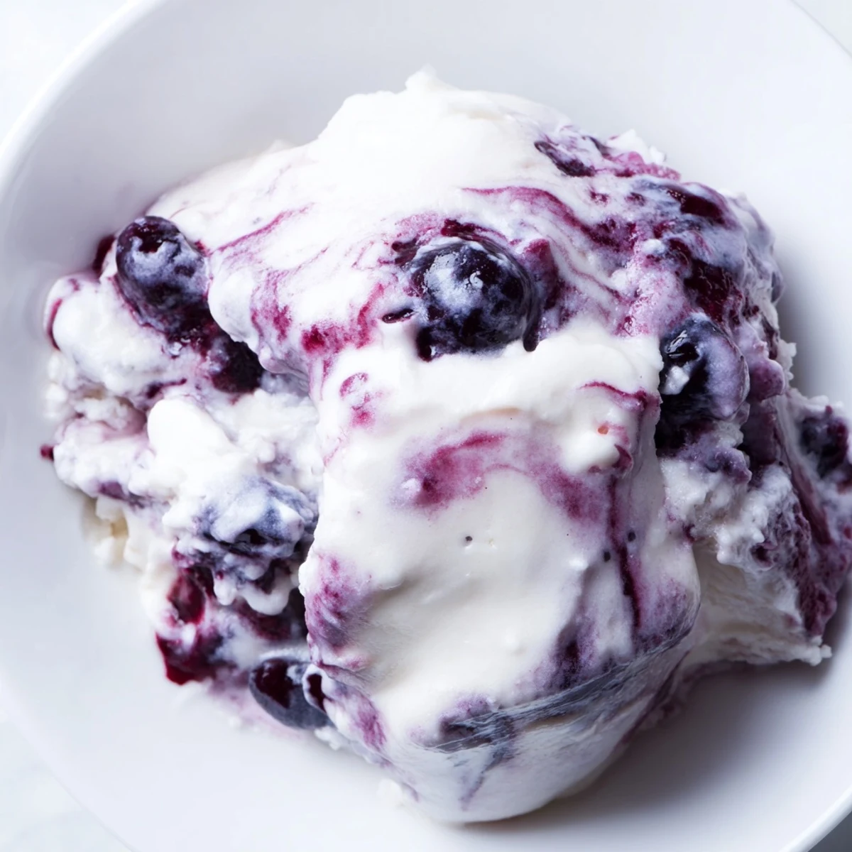 Frozen blueberry swirl yogurt bites featuring purple ribbons swirled through white Greek yogurt