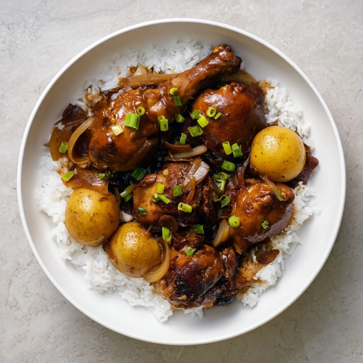 Golden brown chicken thighs braised in savory Filipino Chicken Adobo with garlic and soy sauce