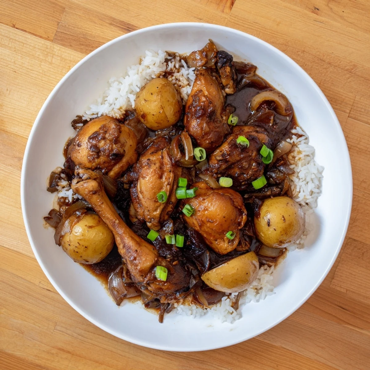 Steaming bowl of Filipino Chicken Adobo served over fluffy white rice with rich dark glaze