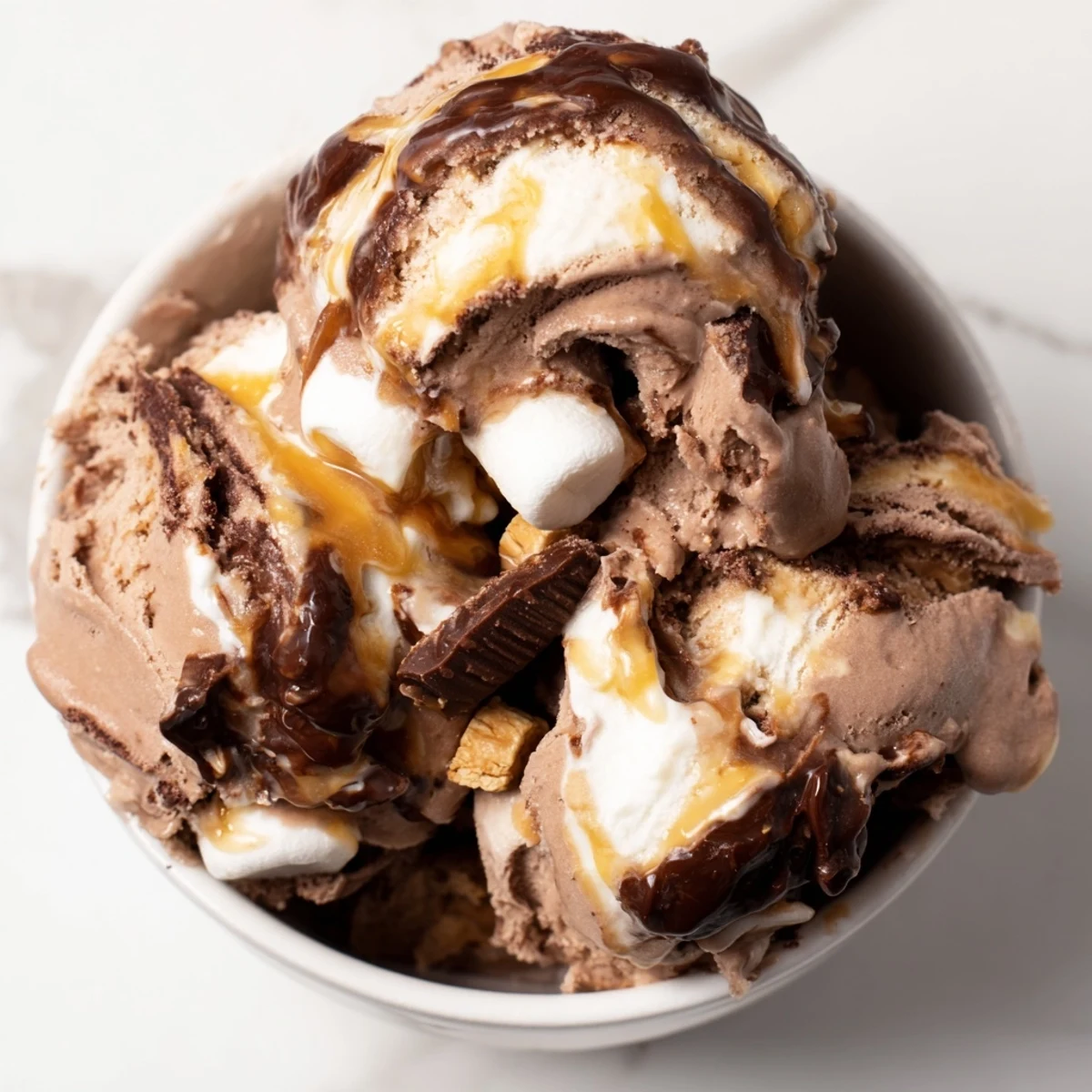 Gorgeous bowl of Ninja Creami Phish Food ice cream featuring thick chocolate custard base with ribbons of golden caramel and fluffy marshmallow swirls.