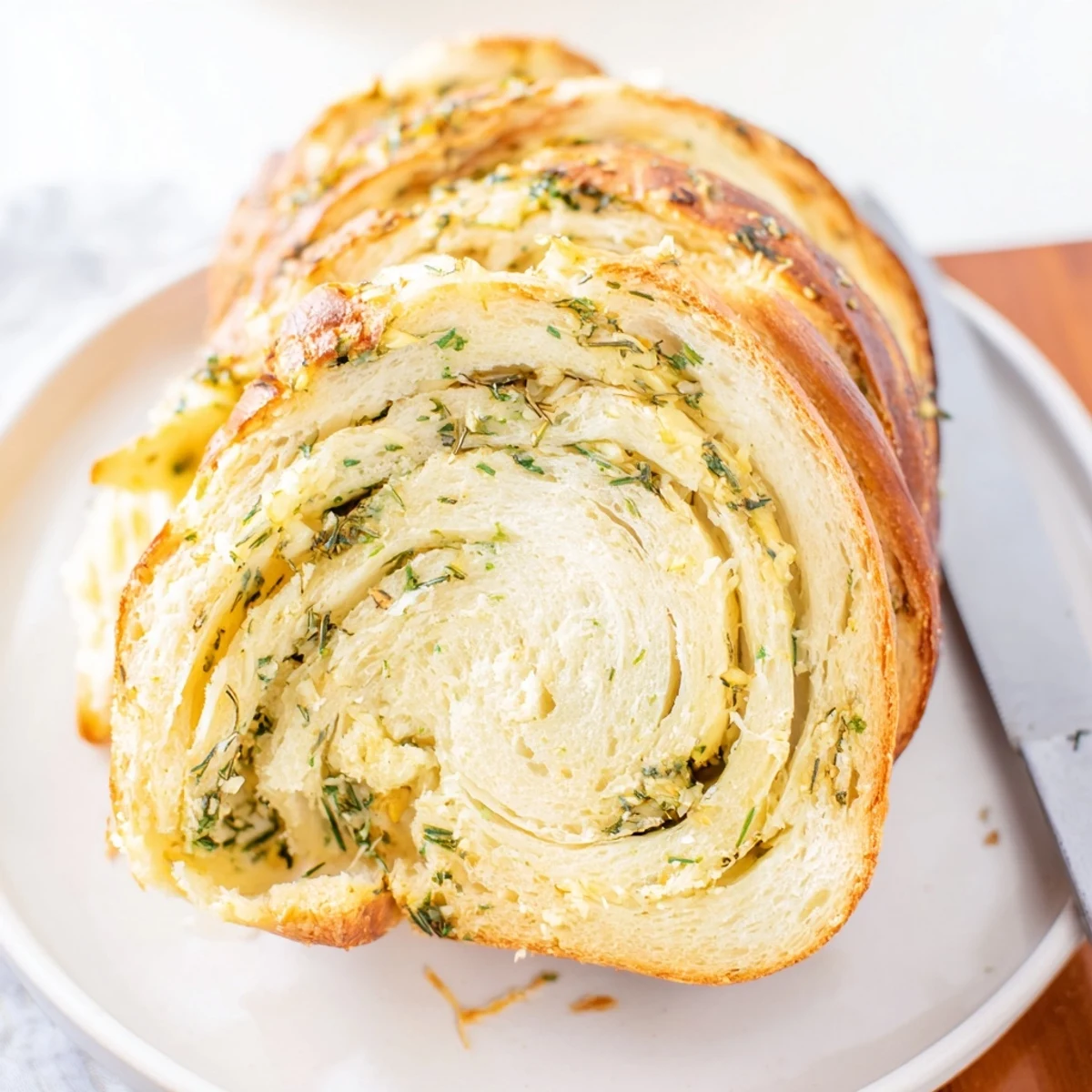 Homemade garlic and herb bread showing soft interior texture and golden crust on serving platter