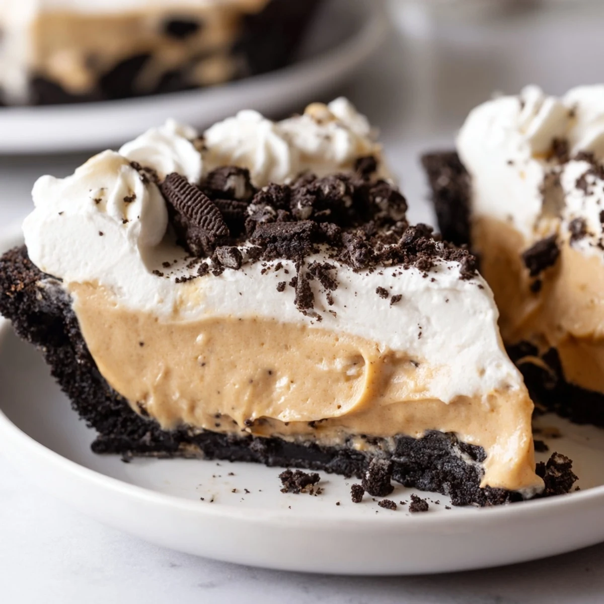 Golden Oreo crust filled with silky peanut butter pie topped with cream