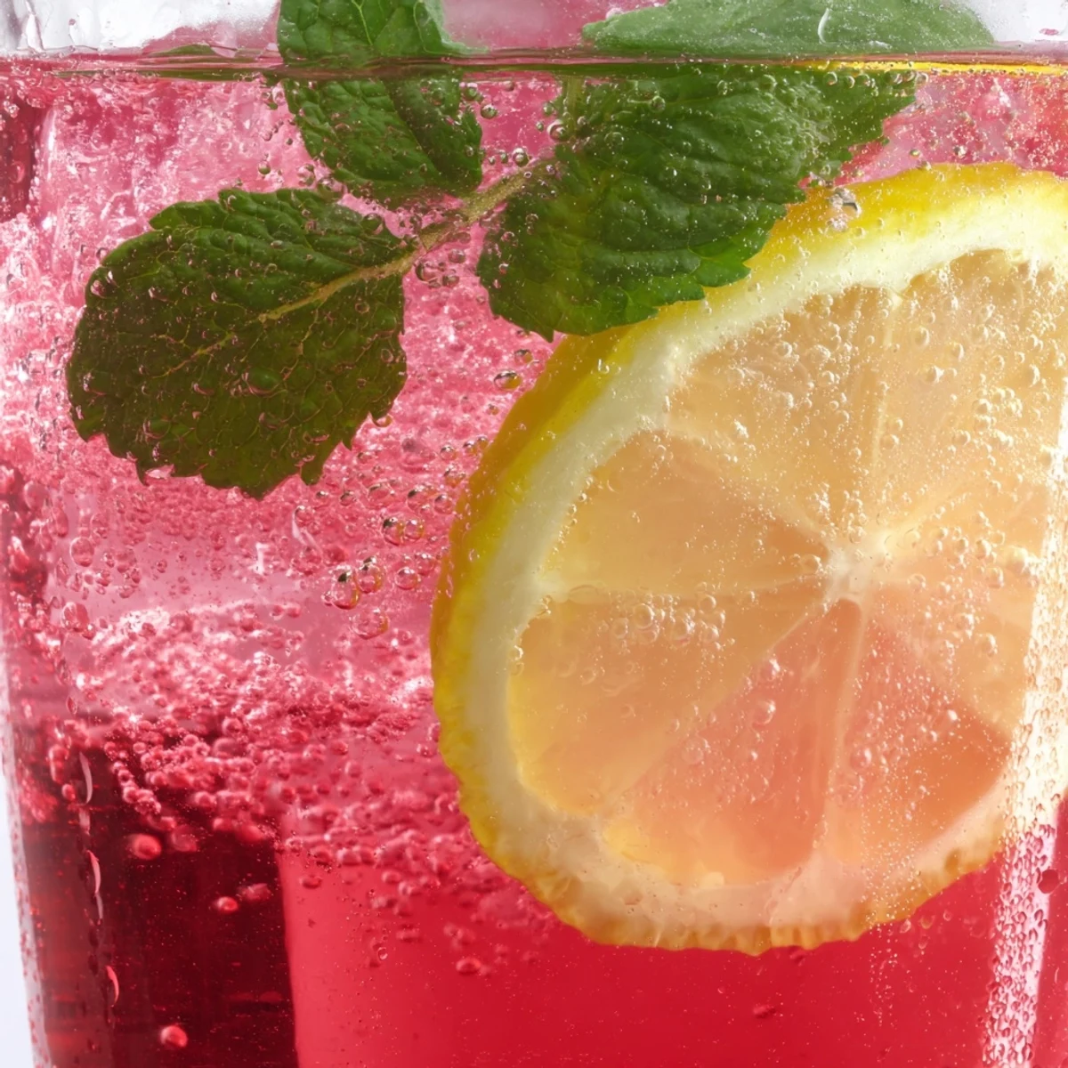 Refreshing honey lemon pink soda served over ice with mint garnish in tall glasses
