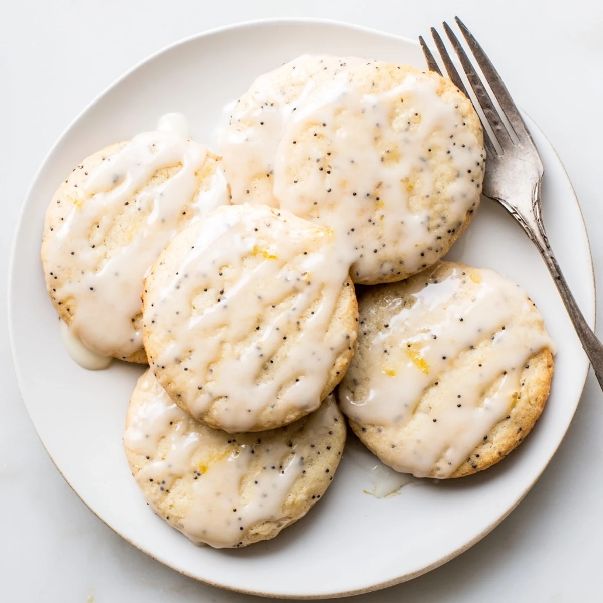 Chewy lemon poppy seed cookies with speckled golden edges cooling on a wire baking rack