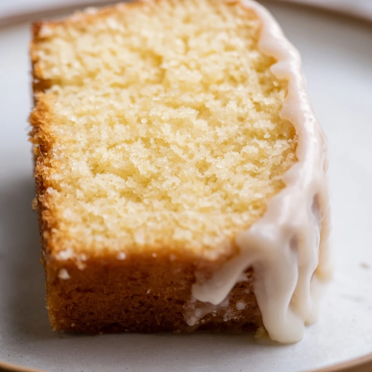 Golden church cake with vanilla glaze drizzled over a moist tender sponge ready for sharing
