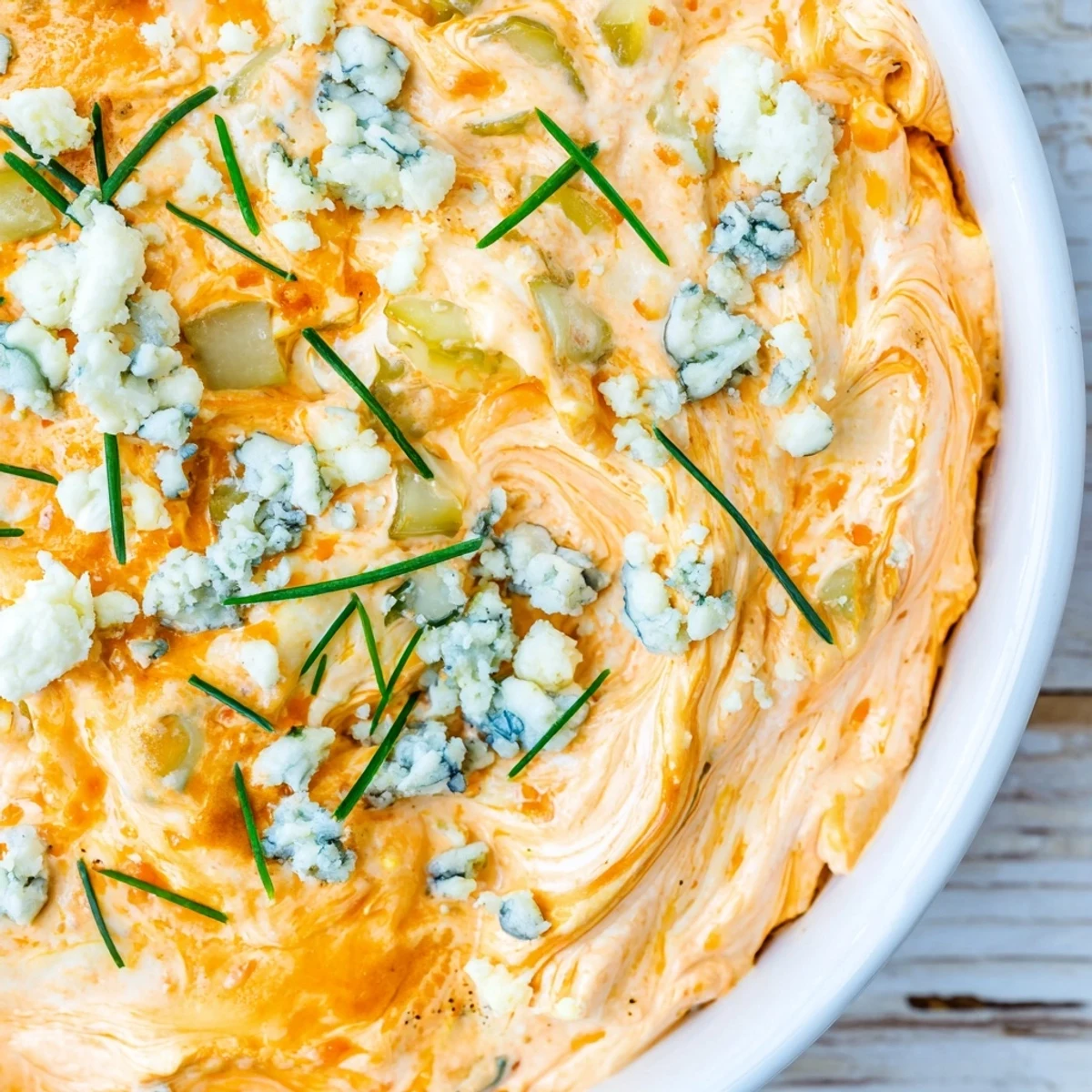 Creamy buffalo pickle dip served in a bowl with crunchy chips for game day snacking