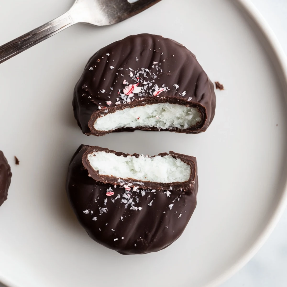 Homemade Peppermint Patties chilled, dipped with a fork, glossy coating, ready for gifting