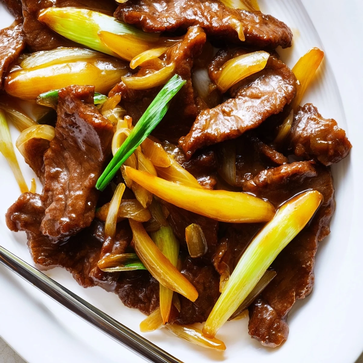 Sizzling wok full of tender seared beef and sweet onions glazed with Asian sauce