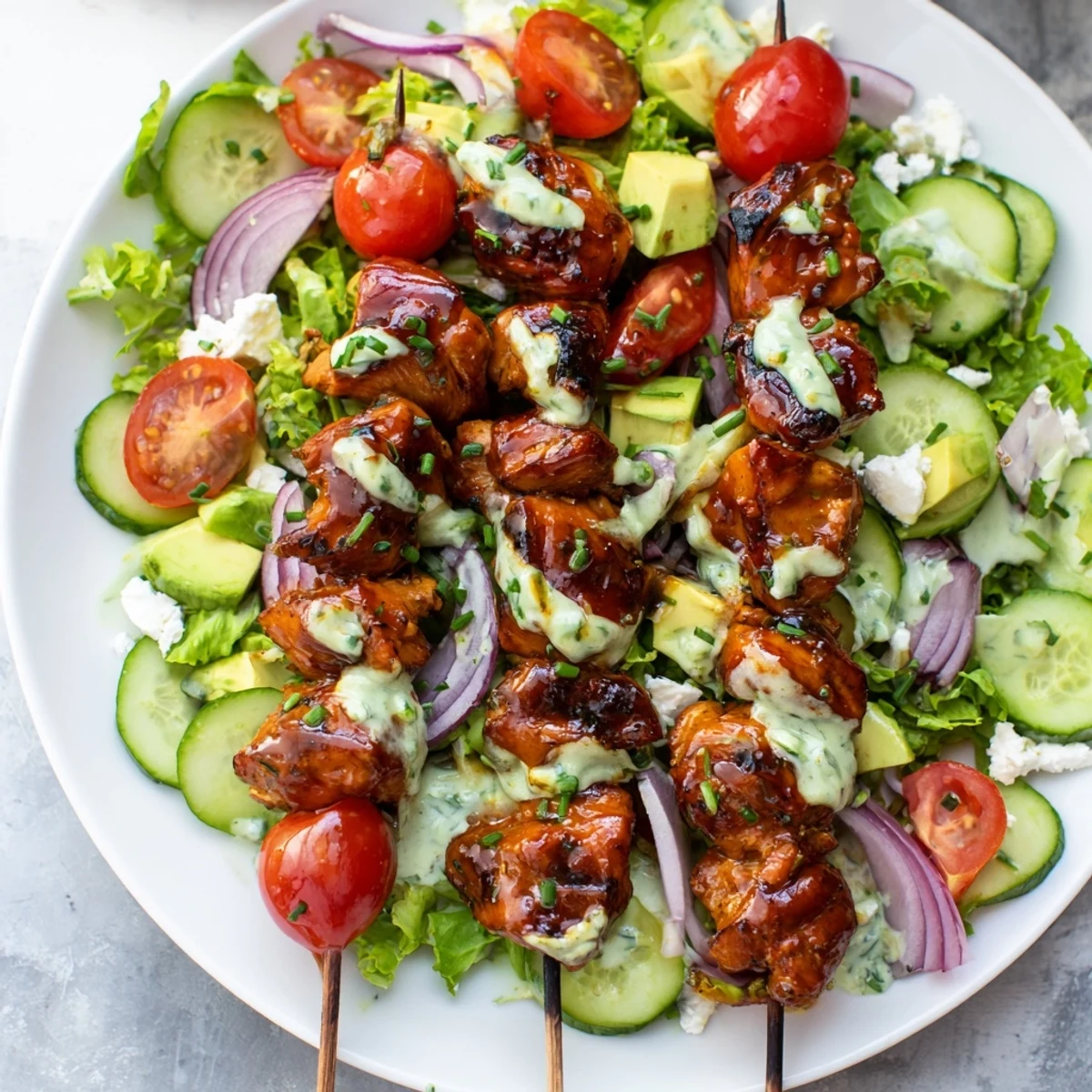 Fresh BBQ chicken skewer salad with juicy grilled chicken atop mixed greens, cherry tomatoes, and creamy herby ranch dressing