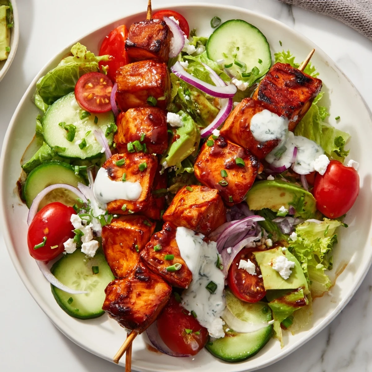 Golden grilled BBQ chicken skewer salad drizzled with homemade herby ranch dressing and served over colorful garden vegetables