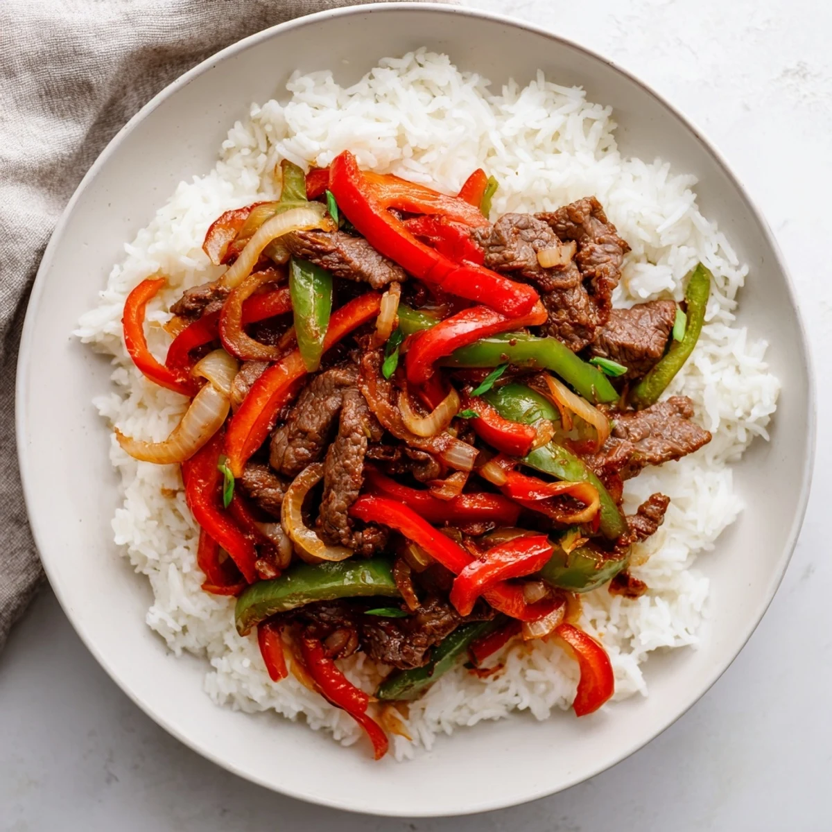 Tender sliced beef strips stir fried with crisp vegetables in a rich spicy chili garlic glaze