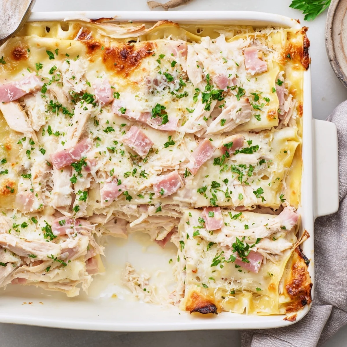Golden bubbly Chicken Cordon Bleu Lasagna with layers of tender chicken ham and melted Swiss cheese