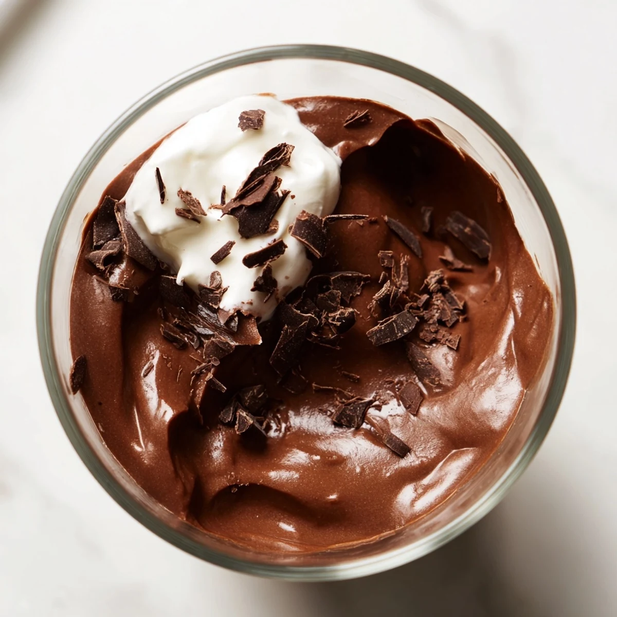Creamy chocolate mousse spooned into dessert cups with a dollop of whipped cream