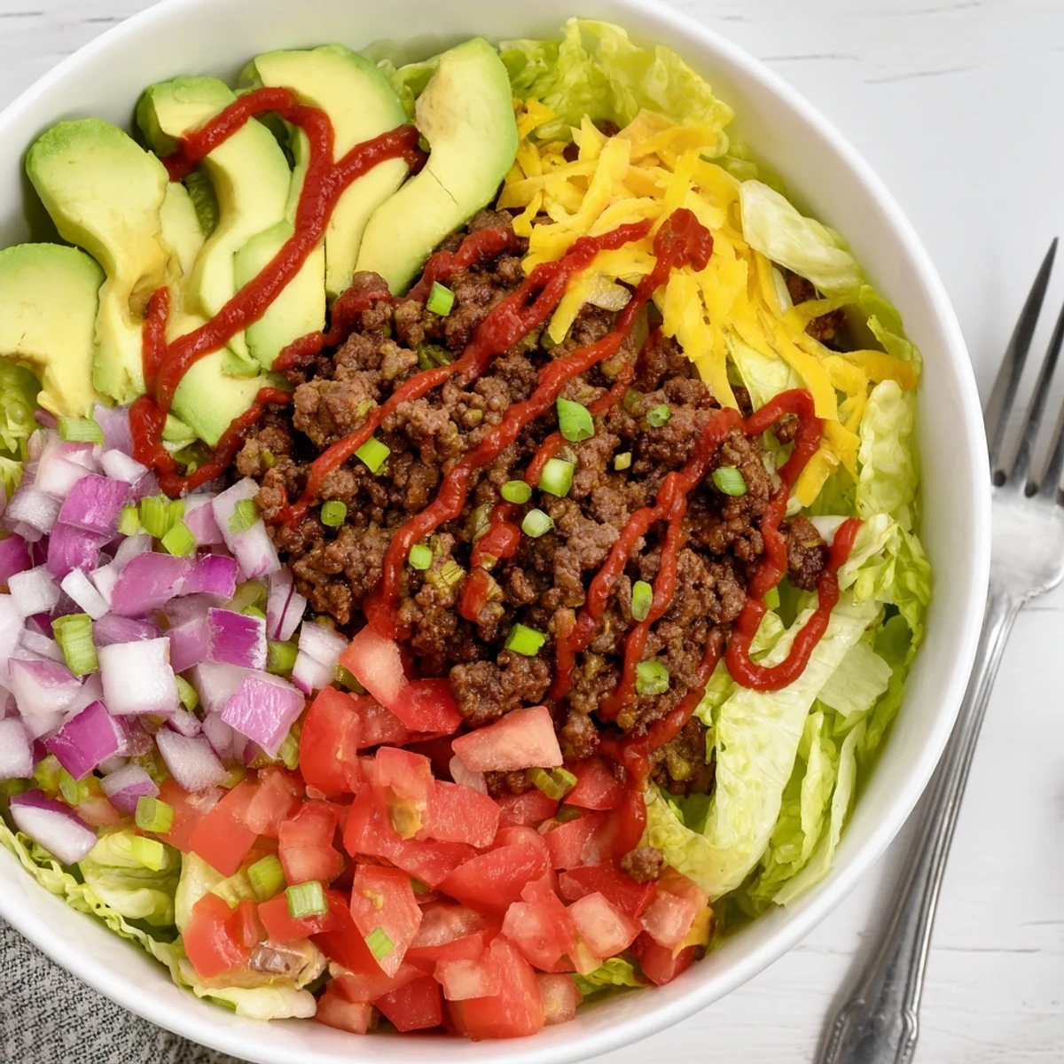 Savory low-carb burger bowl with seasoned beef and fresh vegetable toppings.