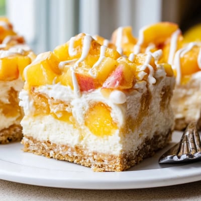 Golden buttery crust beneath luscious Peaches and Cream Cheesecake Bars with juicy peach topping